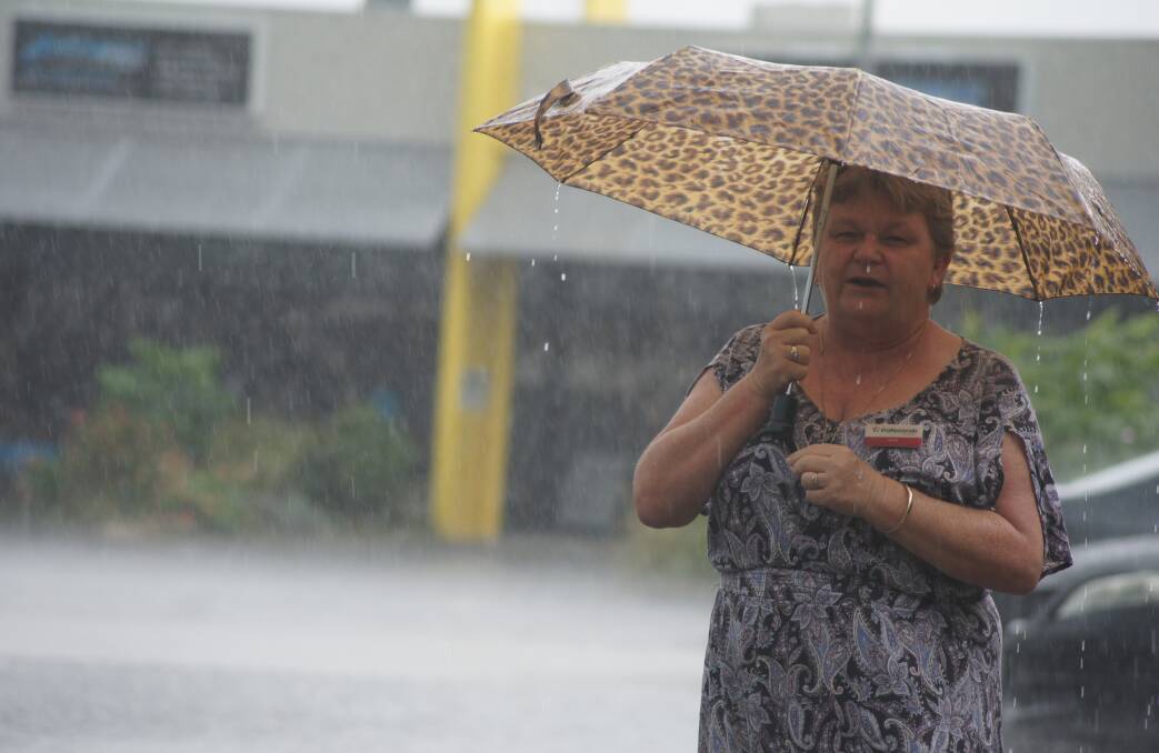 Pouring: Professionals Jimboomba principal Heidi Taylor braved the rain yesterday.